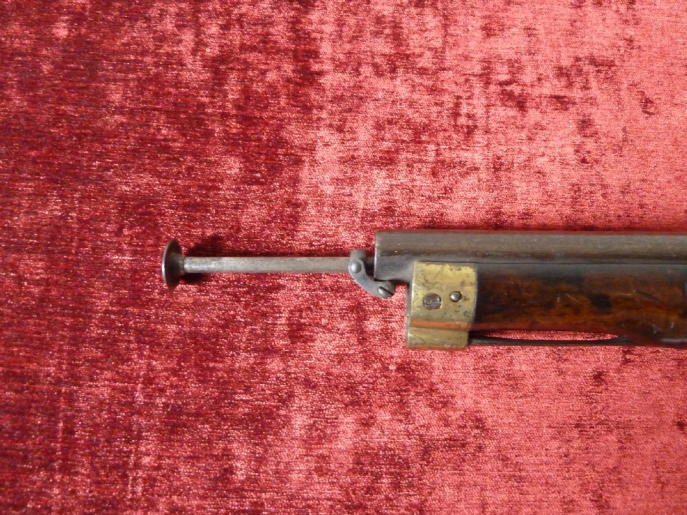An antique 19th-century East India Company percussion pistol with a dark walnut stock, steel barrel and lock, brass trigger guard, and captive swivel ramrod. View XI