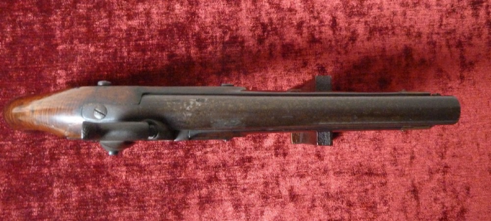 An antique 19th-century East India Company percussion pistol with a dark walnut stock, steel barrel and lock, brass trigger guard, and captive swivel ramrod. View XIV