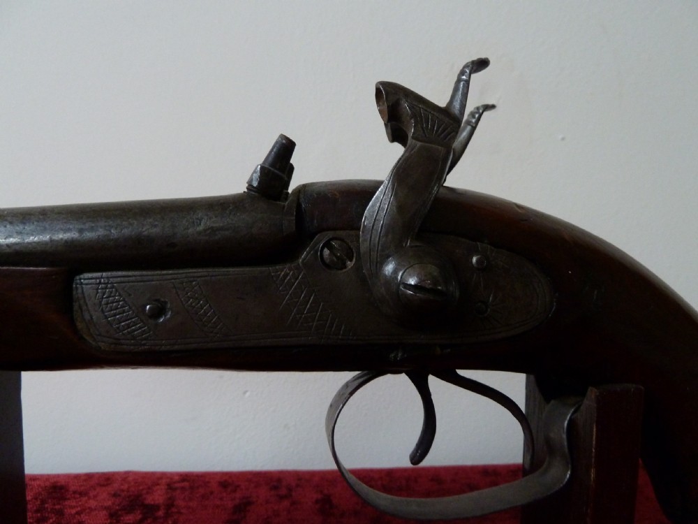 A 19th-century double-barrel percussion pistol featuring side-by-side steel barrels, dual hammers, engraved lockplates, and a smooth walnut stock. View V