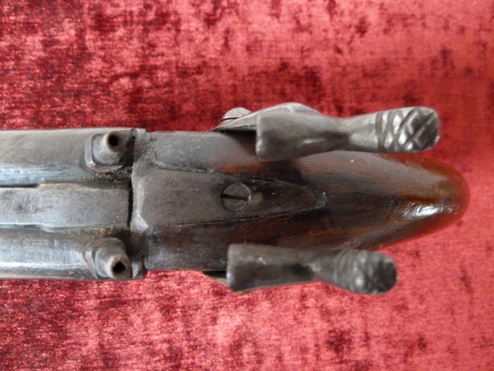 A 19th-century double-barrel percussion pistol featuring side-by-side steel barrels, dual hammers, engraved lockplates, and a smooth walnut stock. View VIII