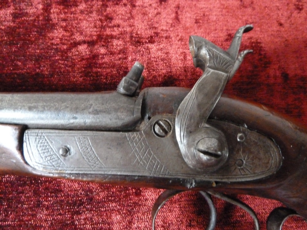 A 19th-century double-barrel percussion pistol featuring side-by-side steel barrels, dual hammers, engraved lockplates, and a smooth walnut stock. View XII