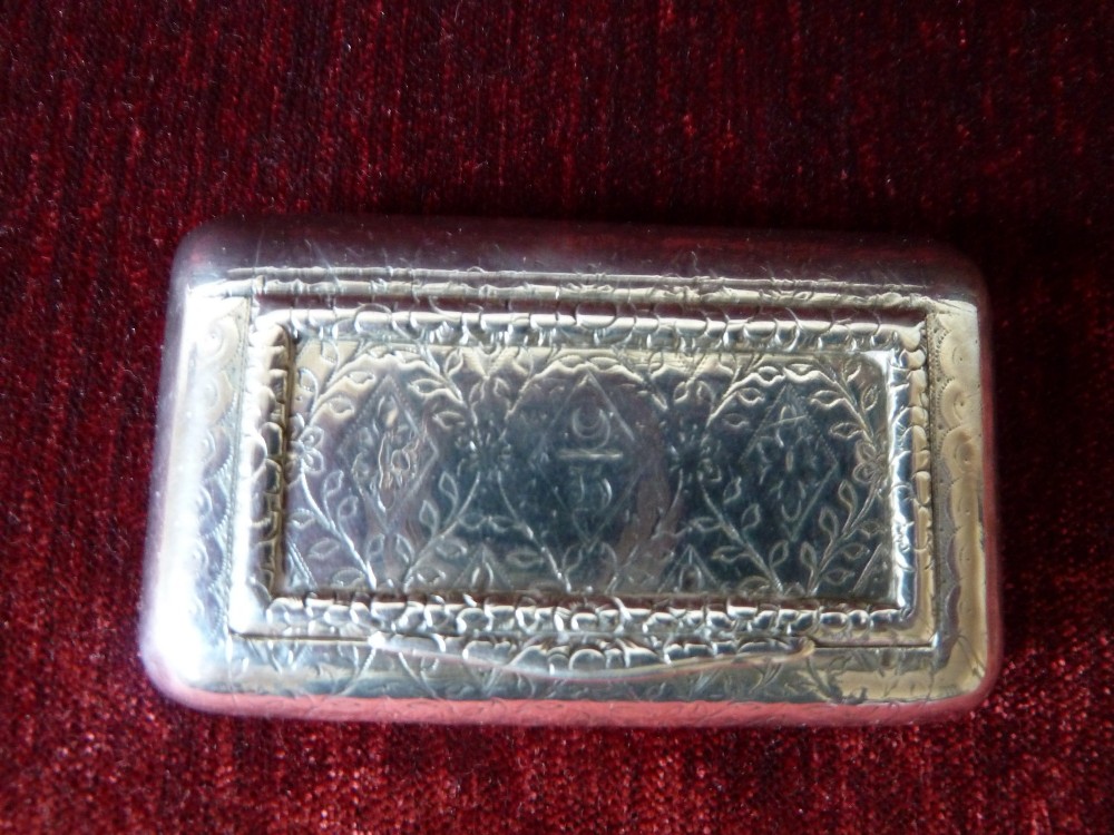 An open rectangular Georgian sterling silver snuff box displaying hallmark stamps on its gilded interior. View II