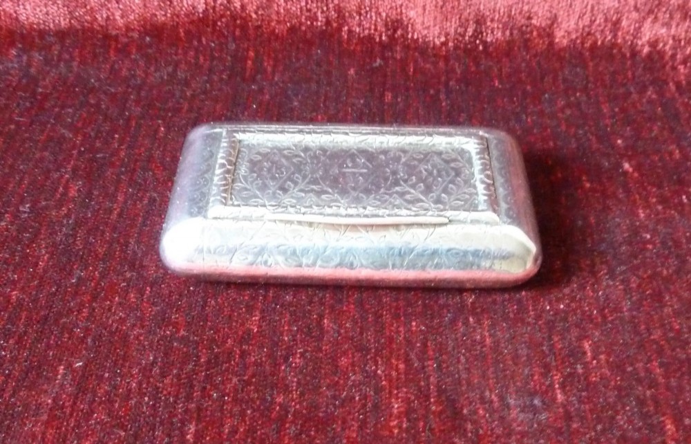 An open rectangular Georgian sterling silver snuff box displaying hallmark stamps on its gilded interior. View III