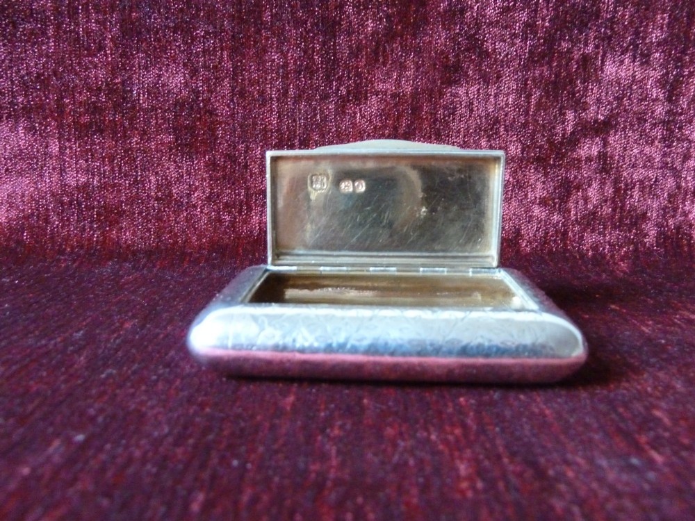 An open rectangular Georgian sterling silver snuff box displaying hallmark stamps on its gilded interior. View IV