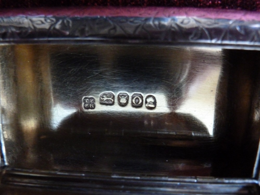 An open rectangular Georgian sterling silver snuff box displaying hallmark stamps on its gilded interior. View V
