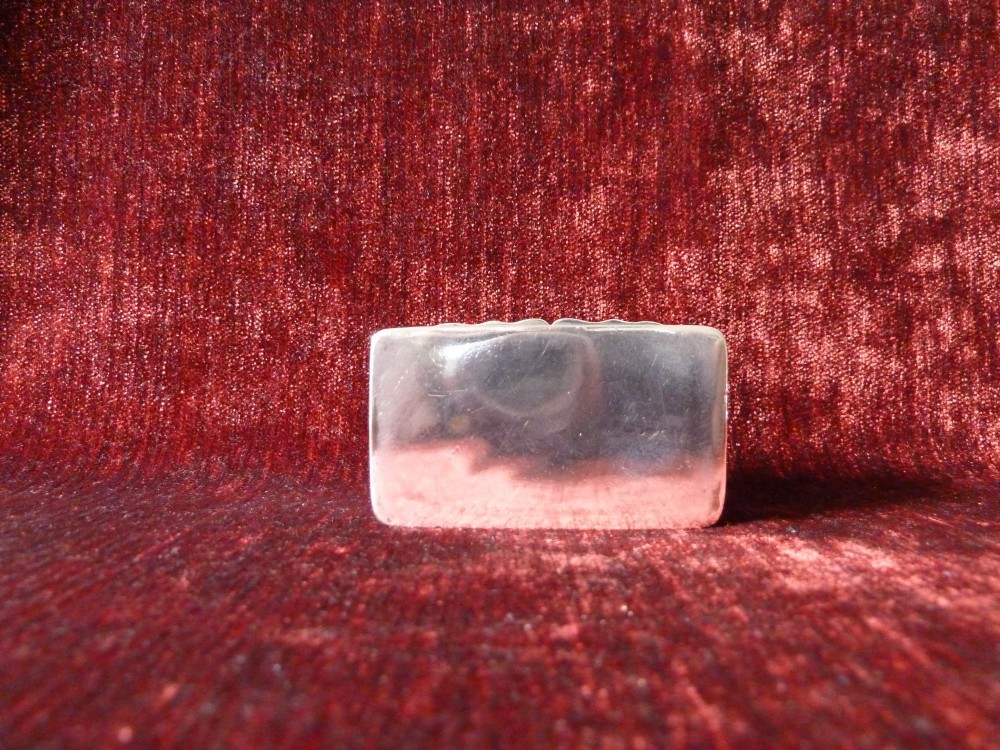 An open rectangular Victorian sterling silver snuff box displaying embossed scrollwork decoration and a gilded interior. View VI