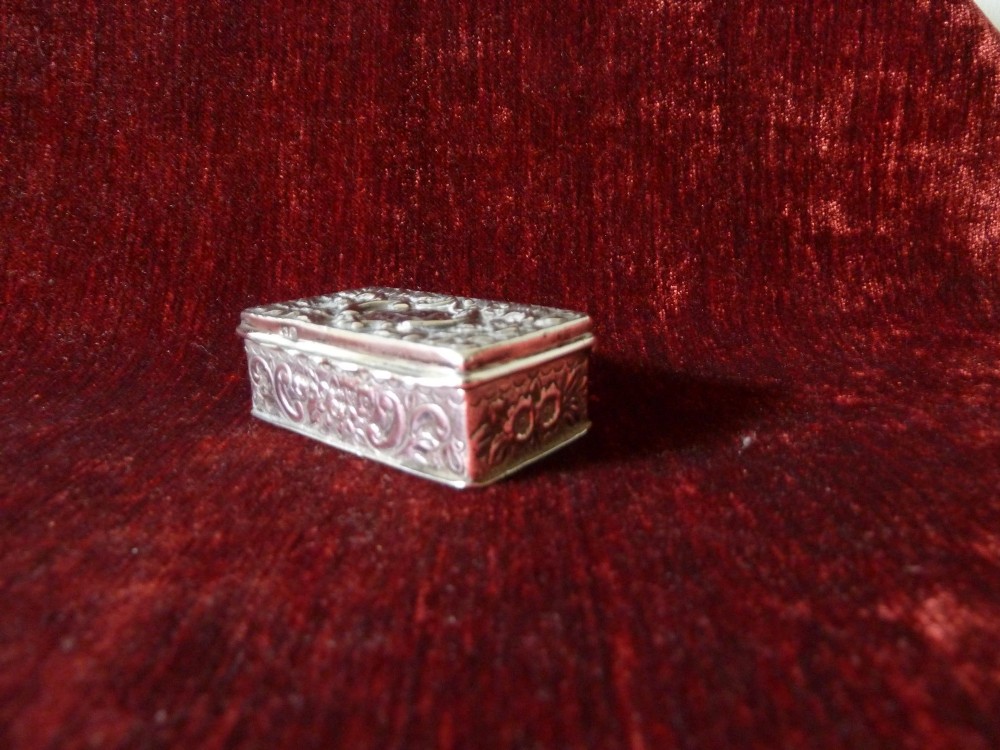 An open rectangular Victorian sterling silver snuff box displaying embossed scrollwork decoration and a gilded interior. View VII