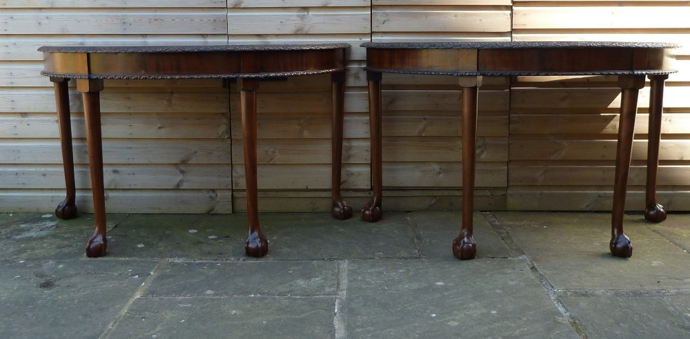 A pair of late 19th-century mahogany demilune console tables featuring carved aprons and cabriole legs with claw-and-ball feet. View II