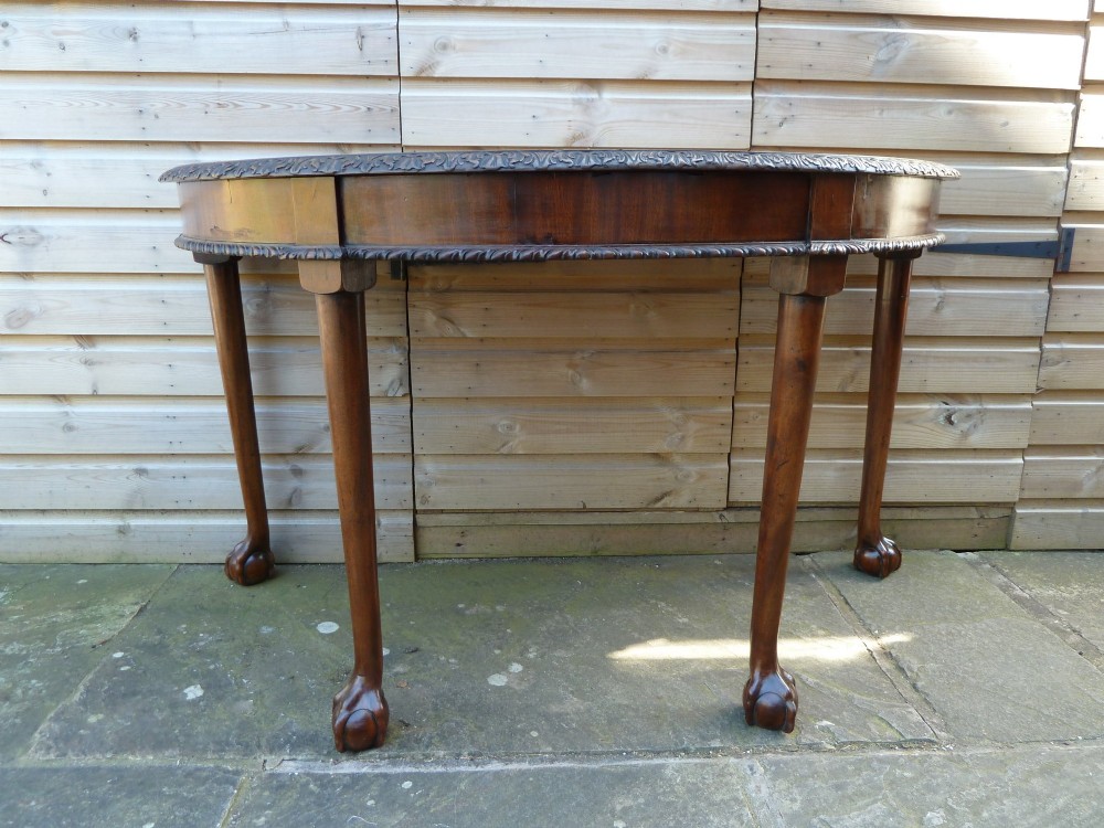 A pair of late 19th-century mahogany demilune console tables featuring carved aprons and cabriole legs with claw-and-ball feet. View IV