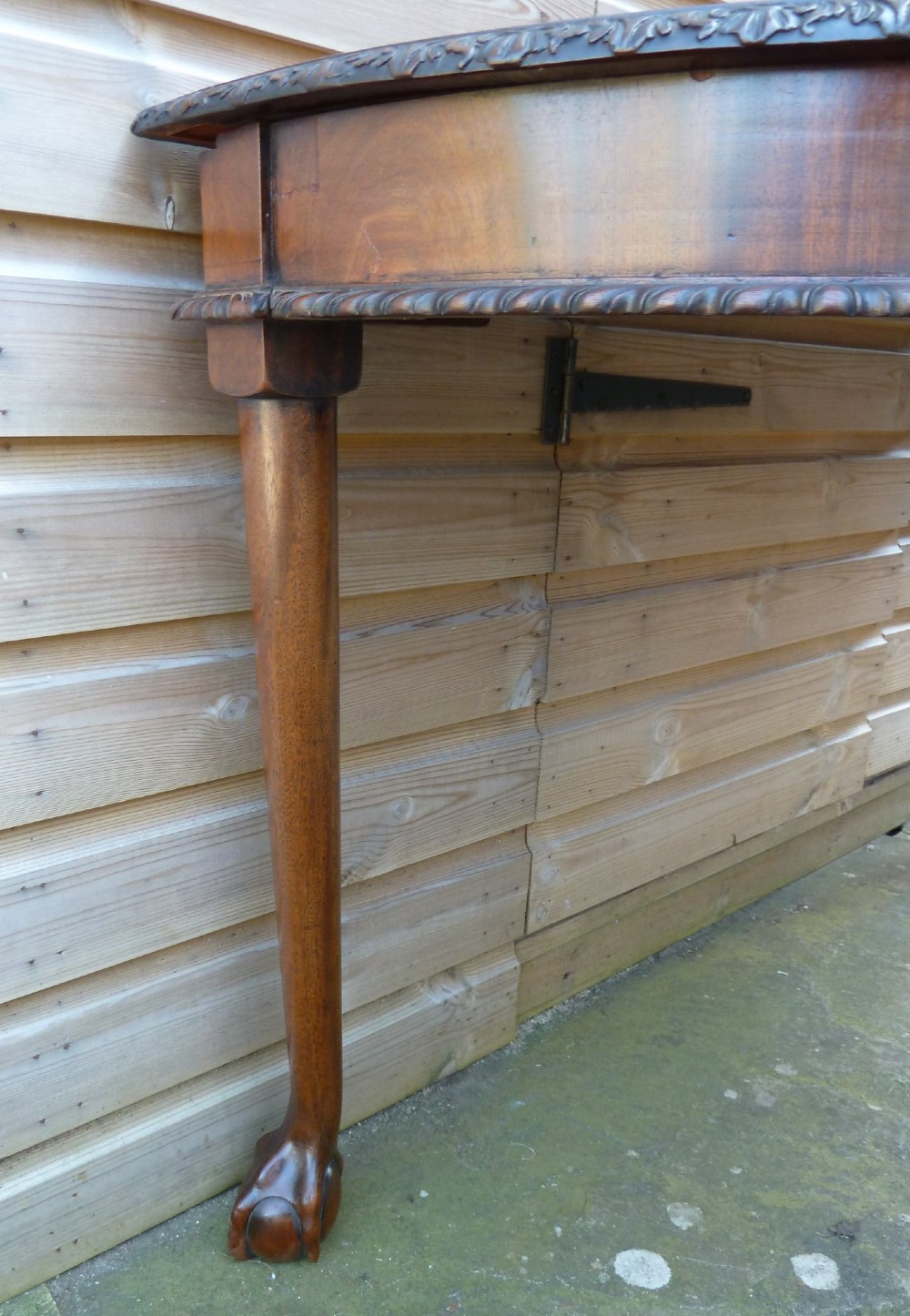 A pair of late 19th-century mahogany demilune console tables featuring carved aprons and cabriole legs with claw-and-ball feet. View V