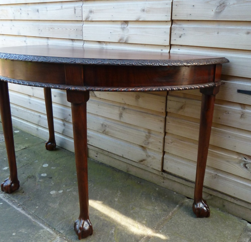 A pair of late 19th-century mahogany demilune console tables featuring carved aprons and cabriole legs with claw-and-ball feet. View VII