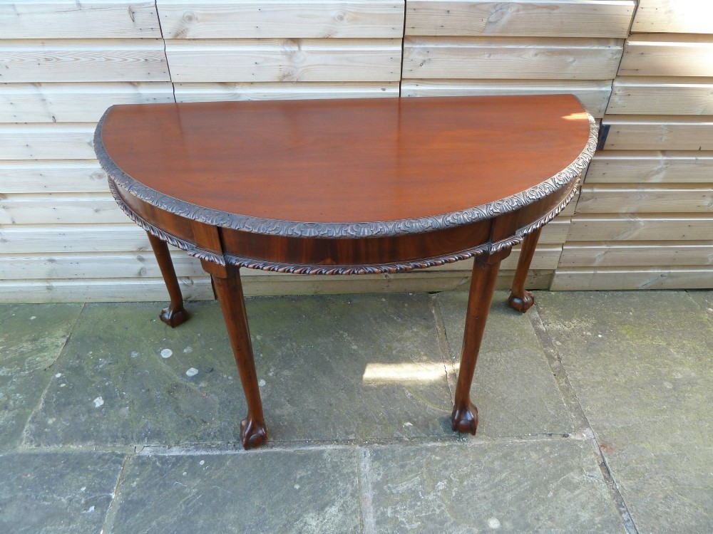 A pair of late 19th-century mahogany demilune console tables featuring carved aprons and cabriole legs with claw-and-ball feet. View VIII