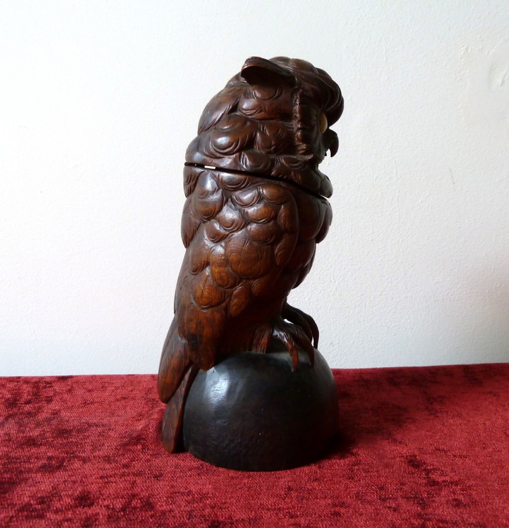 A detailed hand-carved dark wood owl inkwell featuring inset yellow glass eyes perched upon a rounded wooden dome base. View III