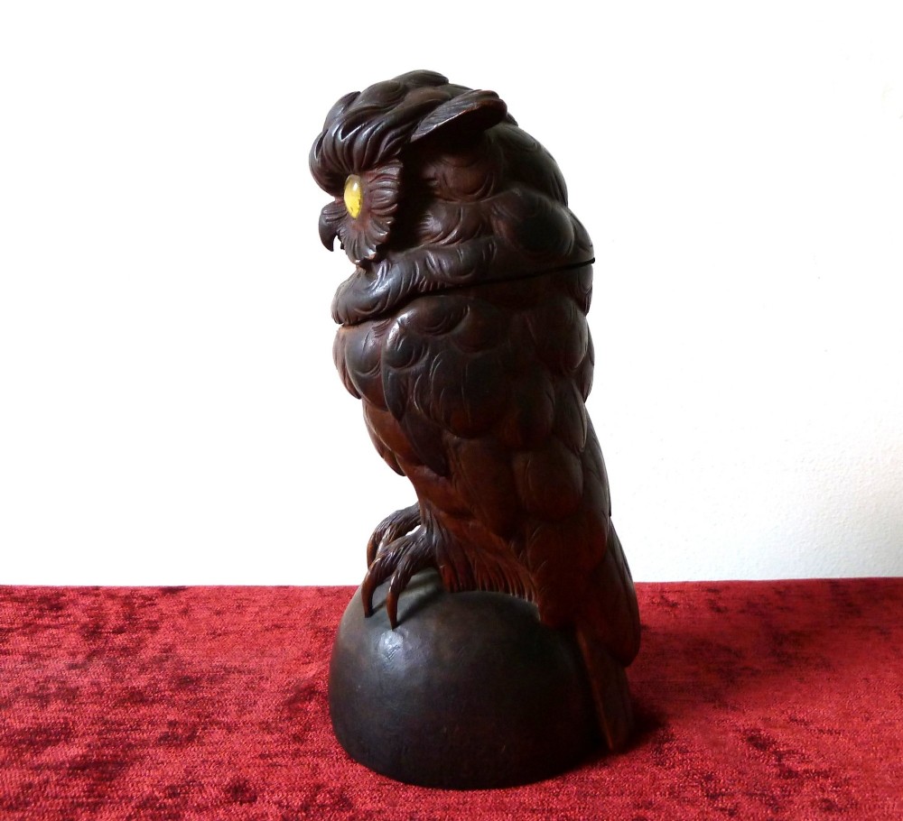 A detailed hand-carved dark wood owl inkwell featuring inset yellow glass eyes perched upon a rounded wooden dome base. View V