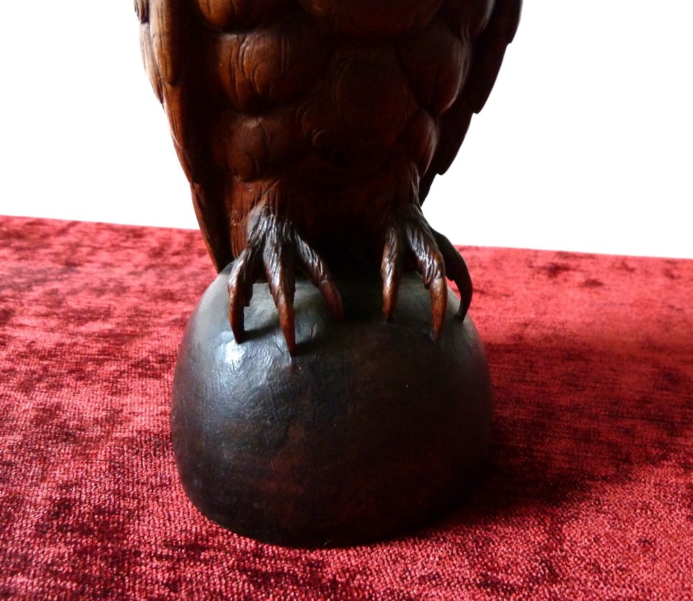 A detailed hand-carved dark wood owl inkwell featuring inset yellow glass eyes perched upon a rounded wooden dome base. View X
