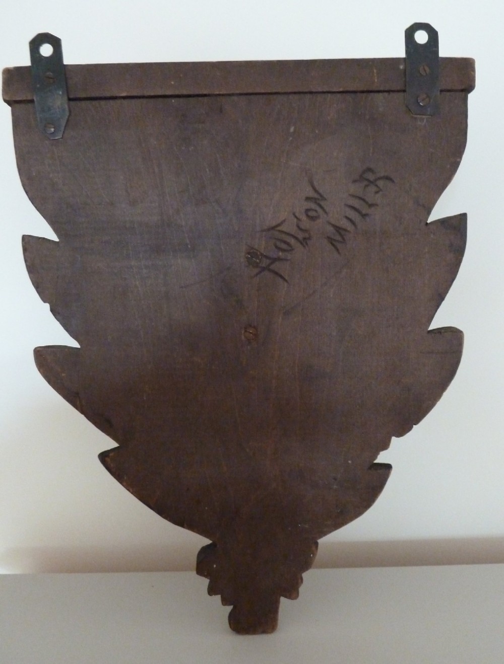 A dark brown hand-carved wooden wall bracket featuring a dog head surrounded by carved leaves below a small rounded shelf. View VI
