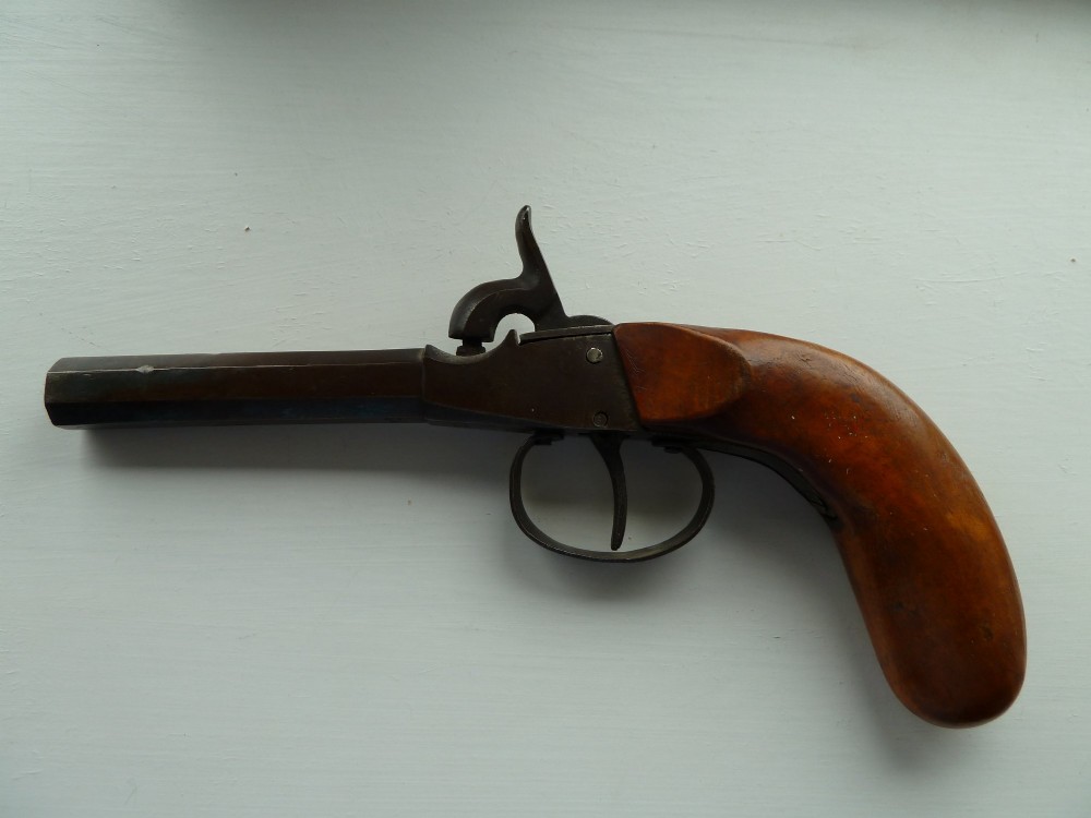 A 19th-century percussion pocket pistol featuring an octagonal steel barrel, iron trigger guard, and smooth curved wooden grip. View II