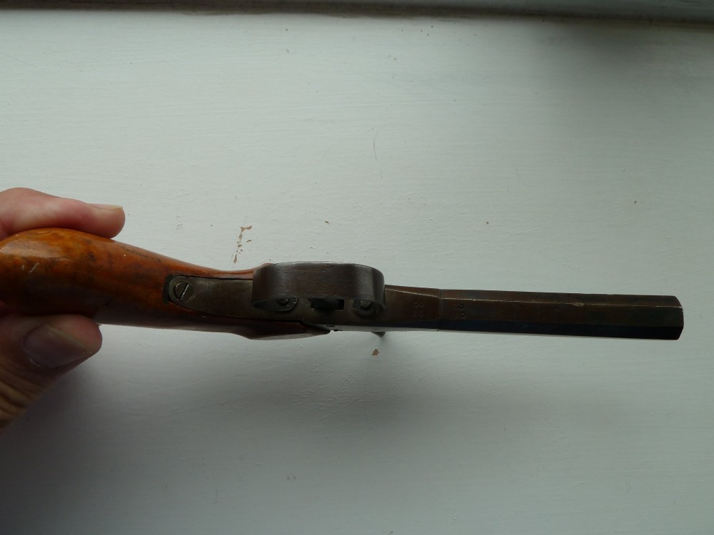A 19th-century percussion pocket pistol featuring an octagonal steel barrel, iron trigger guard, and smooth curved wooden grip. View IV