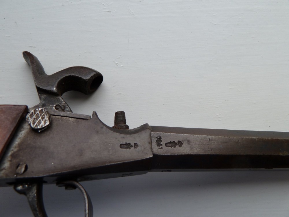 A 19th-century percussion pocket pistol featuring an octagonal steel barrel, iron trigger guard, and smooth curved wooden grip. View VIII