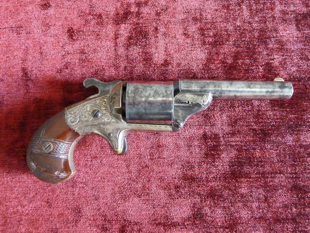 A pair of 19th-century American rimfire pocket revolvers featuring engraved metal frames, cylindrical barrels, and smooth wood grips. View IV