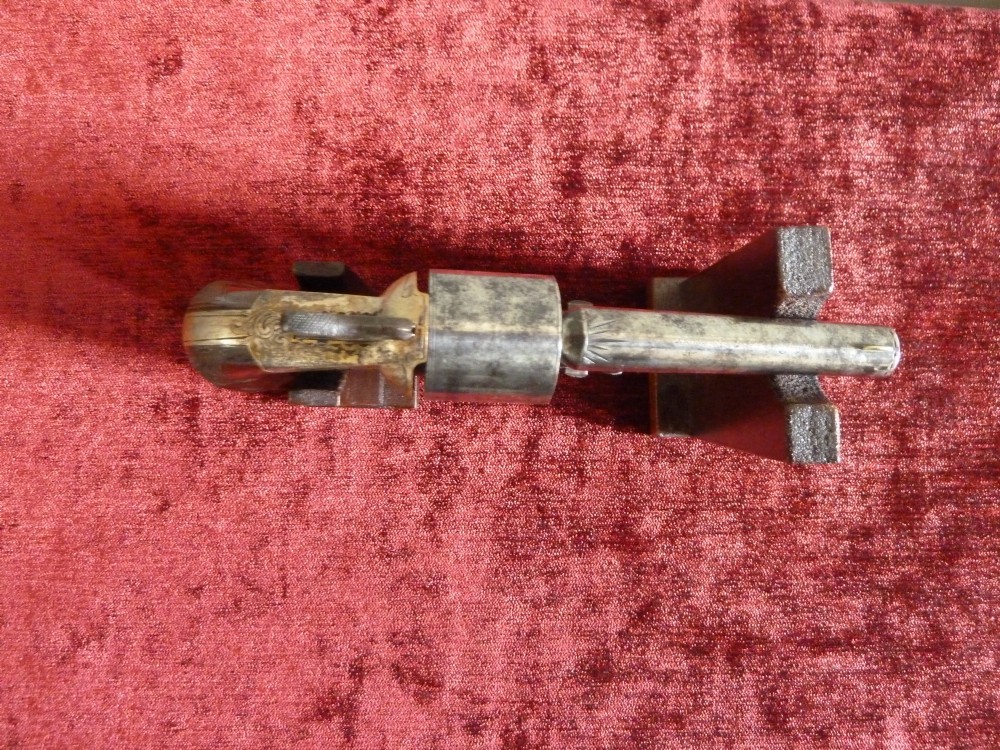 A pair of 19th-century American rimfire pocket revolvers featuring engraved metal frames, cylindrical barrels, and smooth wood grips. View VIII