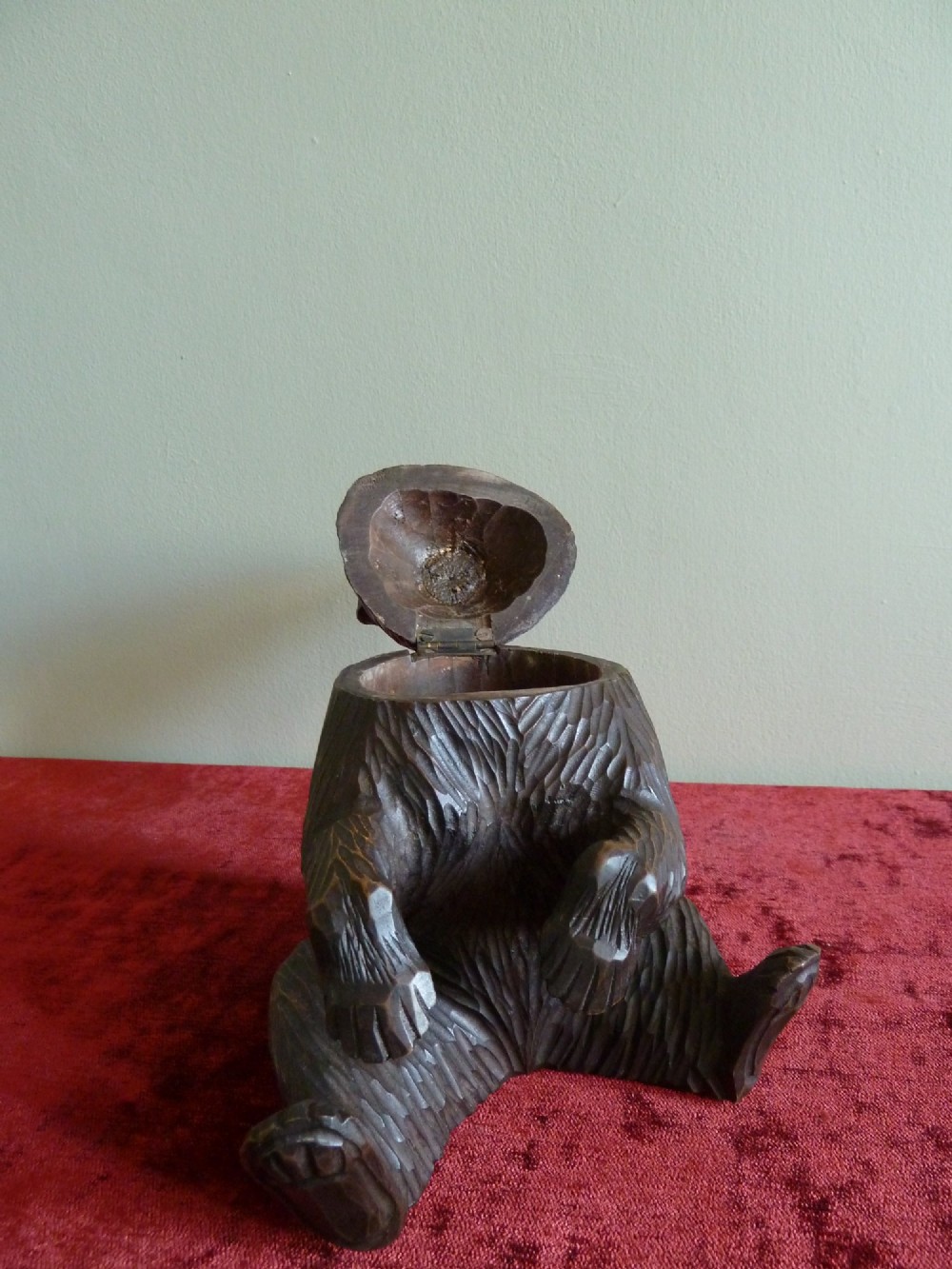 A carved dark brown wooden Black Forest bear depicted in a seated position with open jaws, featuring a removable head function. View III
