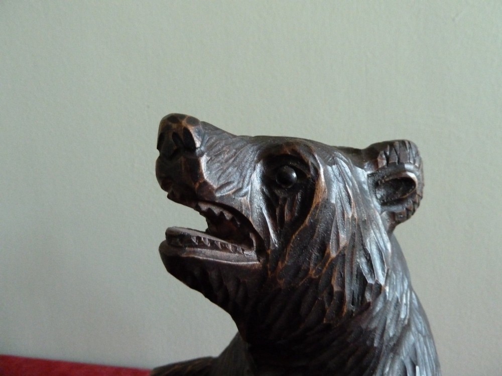 A carved dark brown wooden Black Forest bear depicted in a seated position with open jaws, featuring a removable head function. View VI