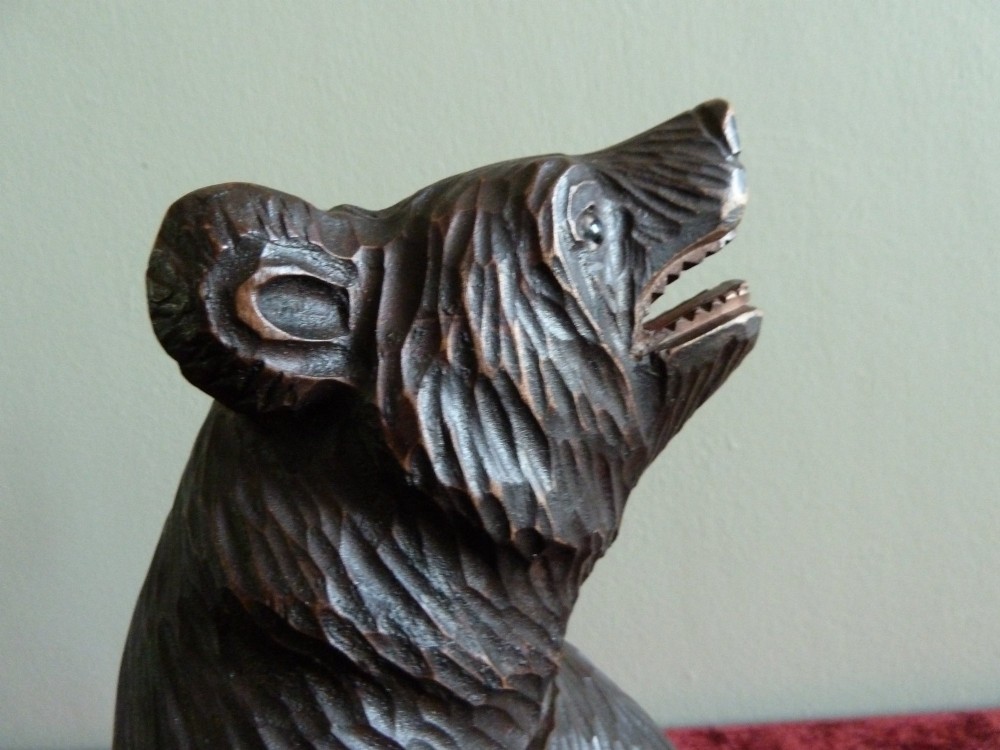 A carved dark brown wooden Black Forest bear depicted in a seated position with open jaws, featuring a removable head function. View VII