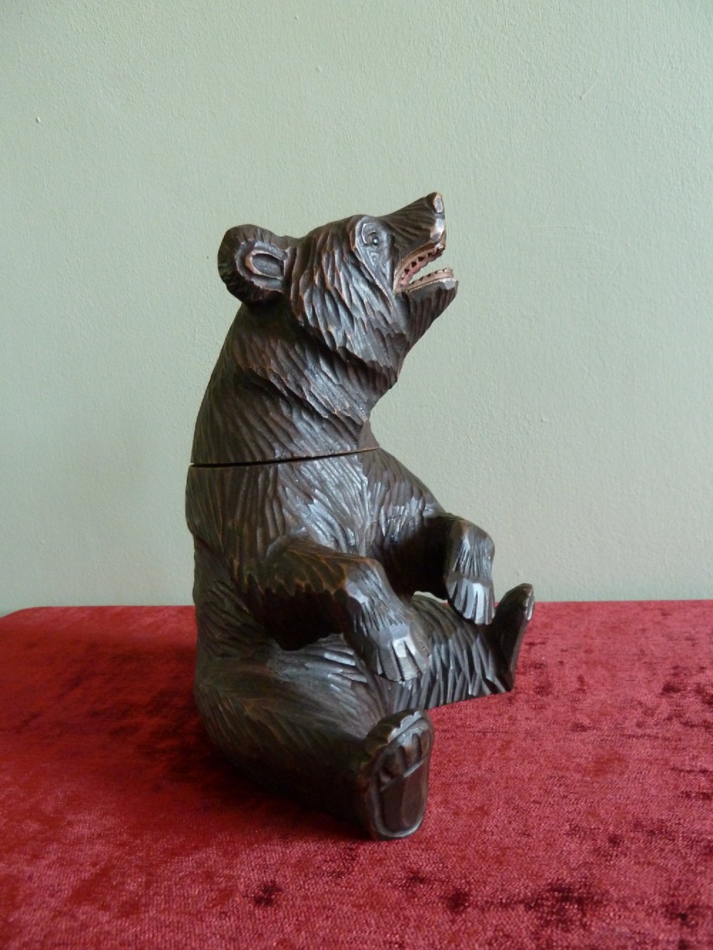 A carved dark brown wooden Black Forest bear depicted in a seated position with open jaws, featuring a removable head function. View VIII
