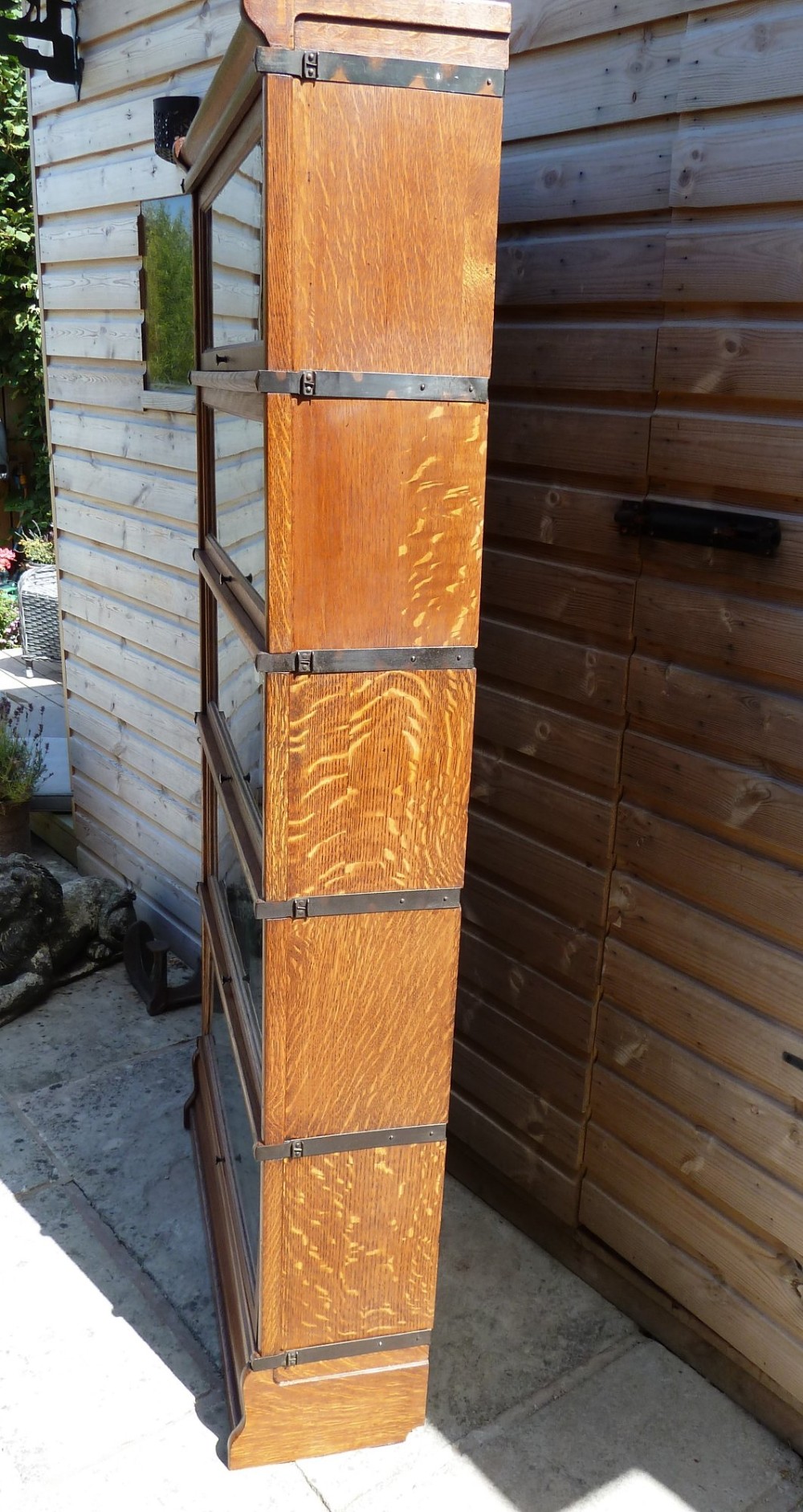 A five-tier golden oak Globe Wernicke modular bookcase featuring glazed up-and-over doors and brass knob handles. View IV