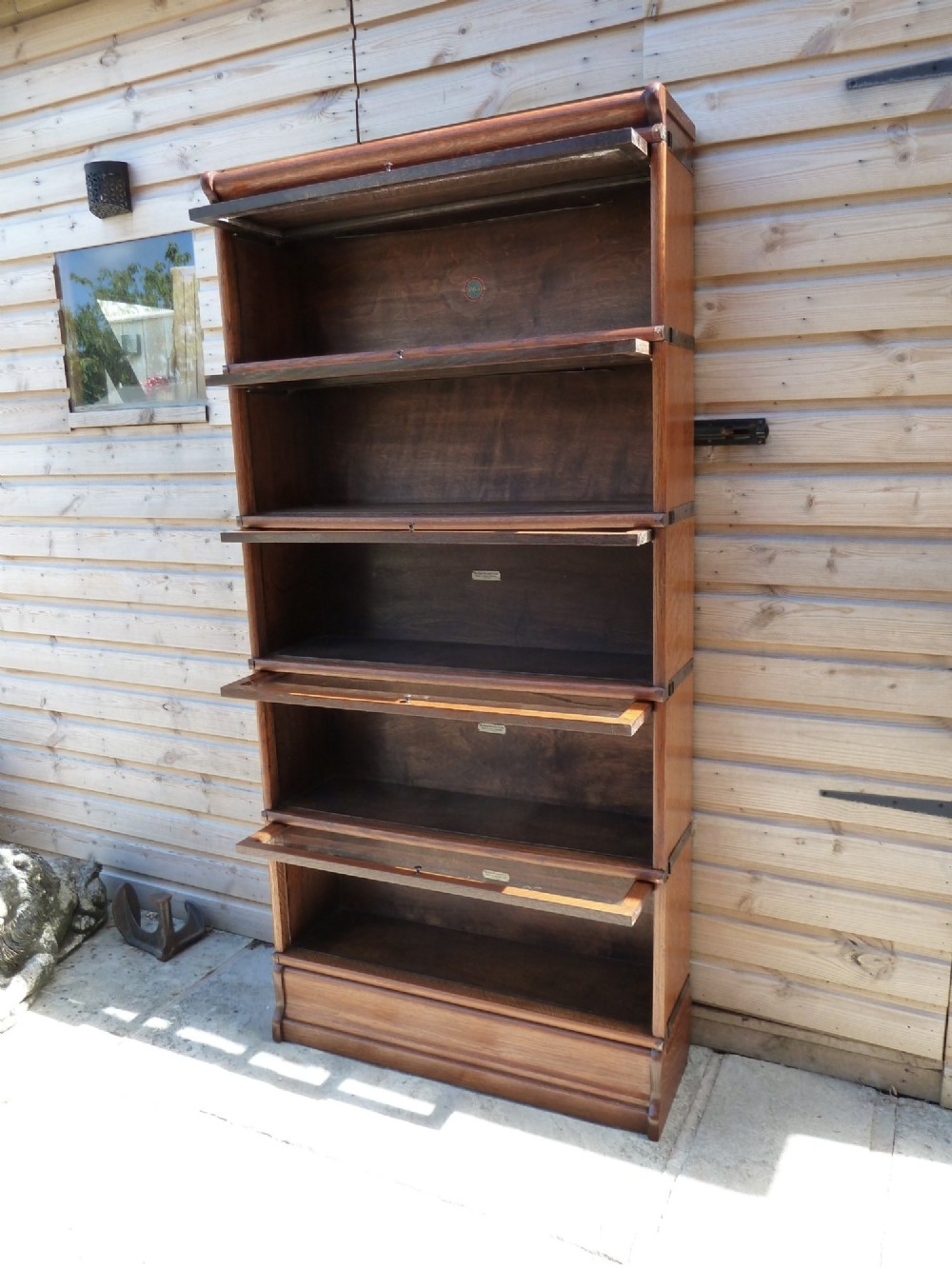 A five-tier golden oak Globe Wernicke modular bookcase featuring glazed up-and-over doors and brass knob handles. View VIII