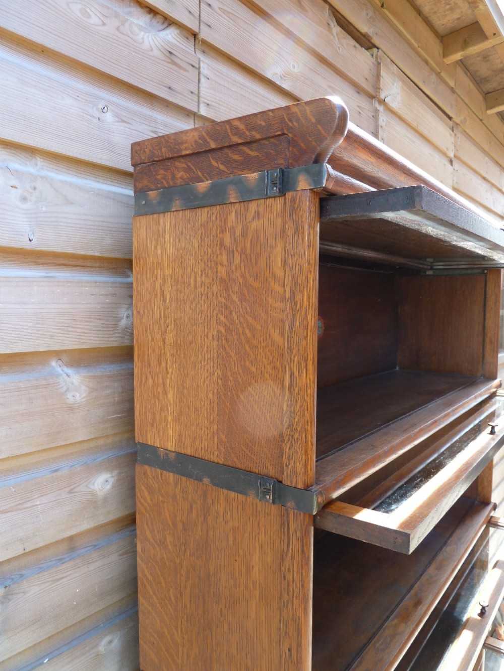 A five-tier golden oak Globe Wernicke modular bookcase featuring glazed up-and-over doors and brass knob handles. View XI