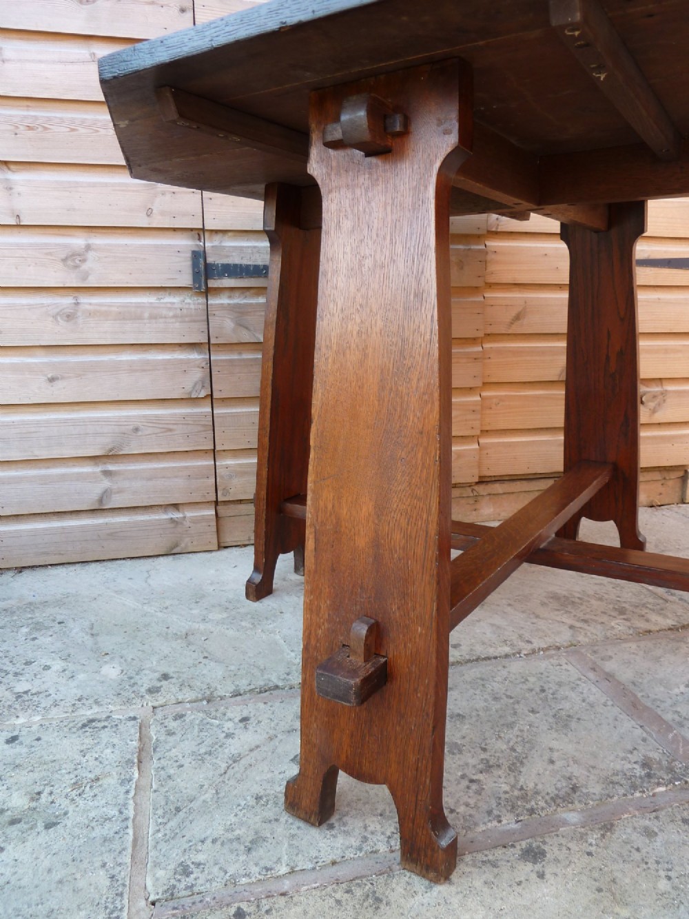 An octagonal solid dark oak Arts and Crafts centre table featuring an exposed tusk tenon cross-stretcher base. View IV