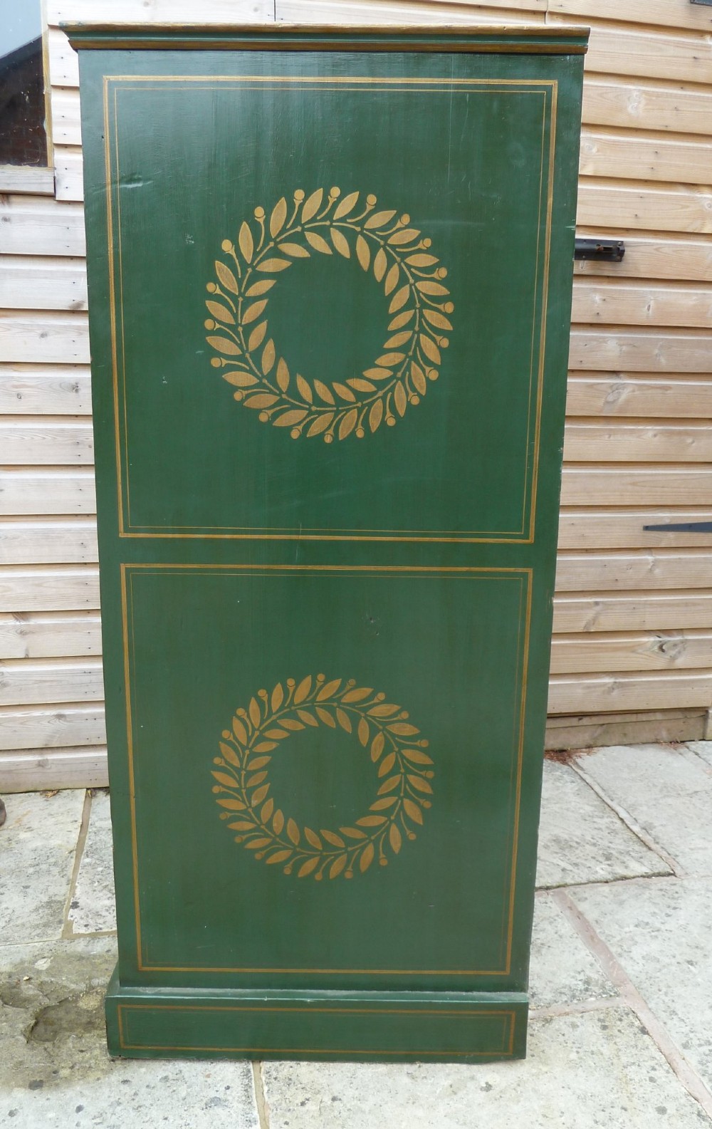 A tall dark green painted pine office chest featuring eight drawers with brass ring handles and gold pinstripe lining. View V