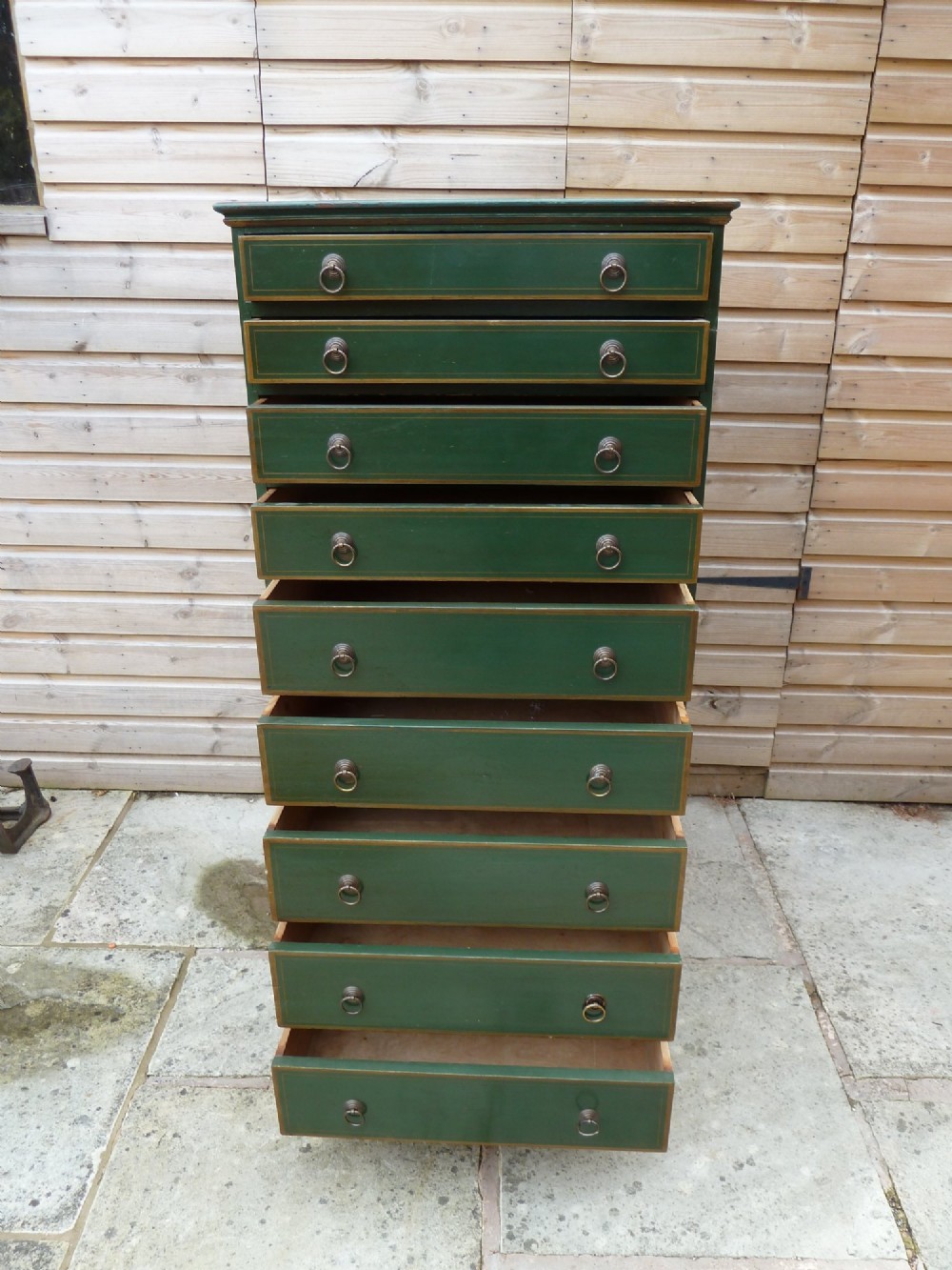 A tall dark green painted pine office chest featuring eight drawers with brass ring handles and gold pinstripe lining. View XI
