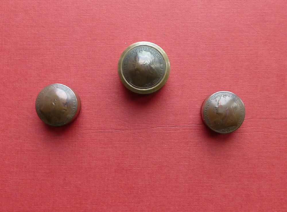 Three small circular antique brass snuff boxes with lids featuring raised profile portraits of British monarchs.