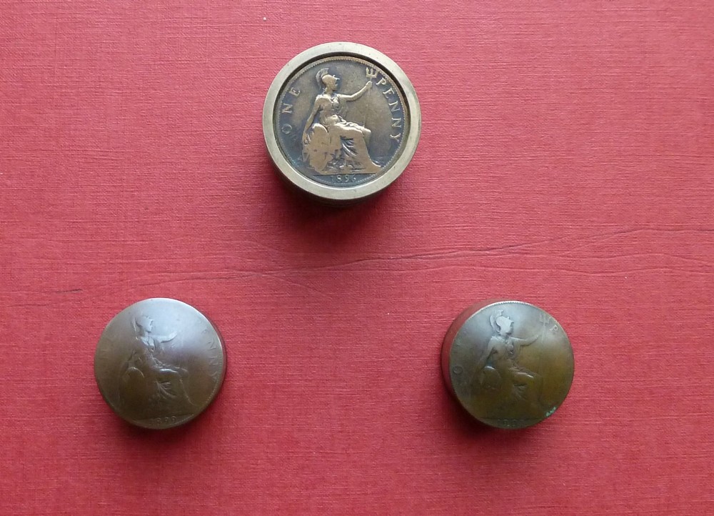 Three small circular antique brass snuff boxes with lids featuring raised profile portraits of British monarchs. View V