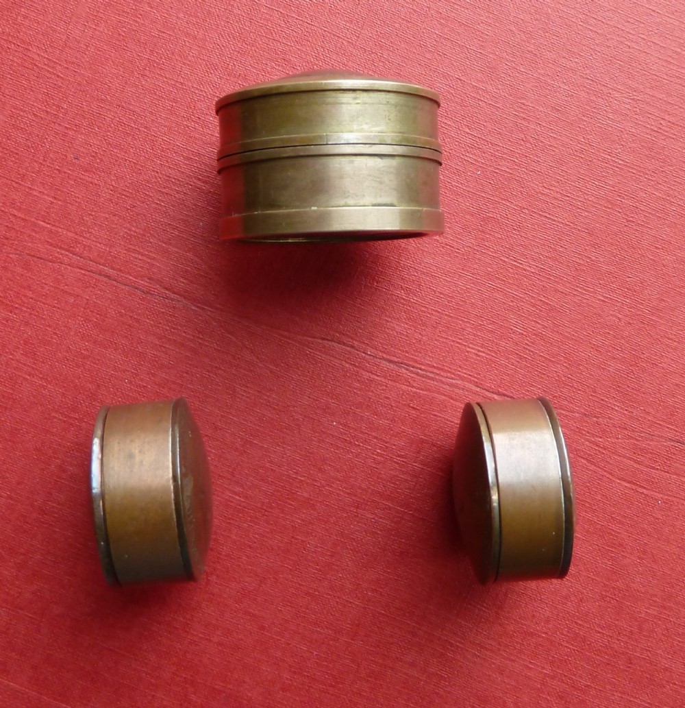 Three small circular antique brass snuff boxes with lids featuring raised profile portraits of British monarchs. View VI