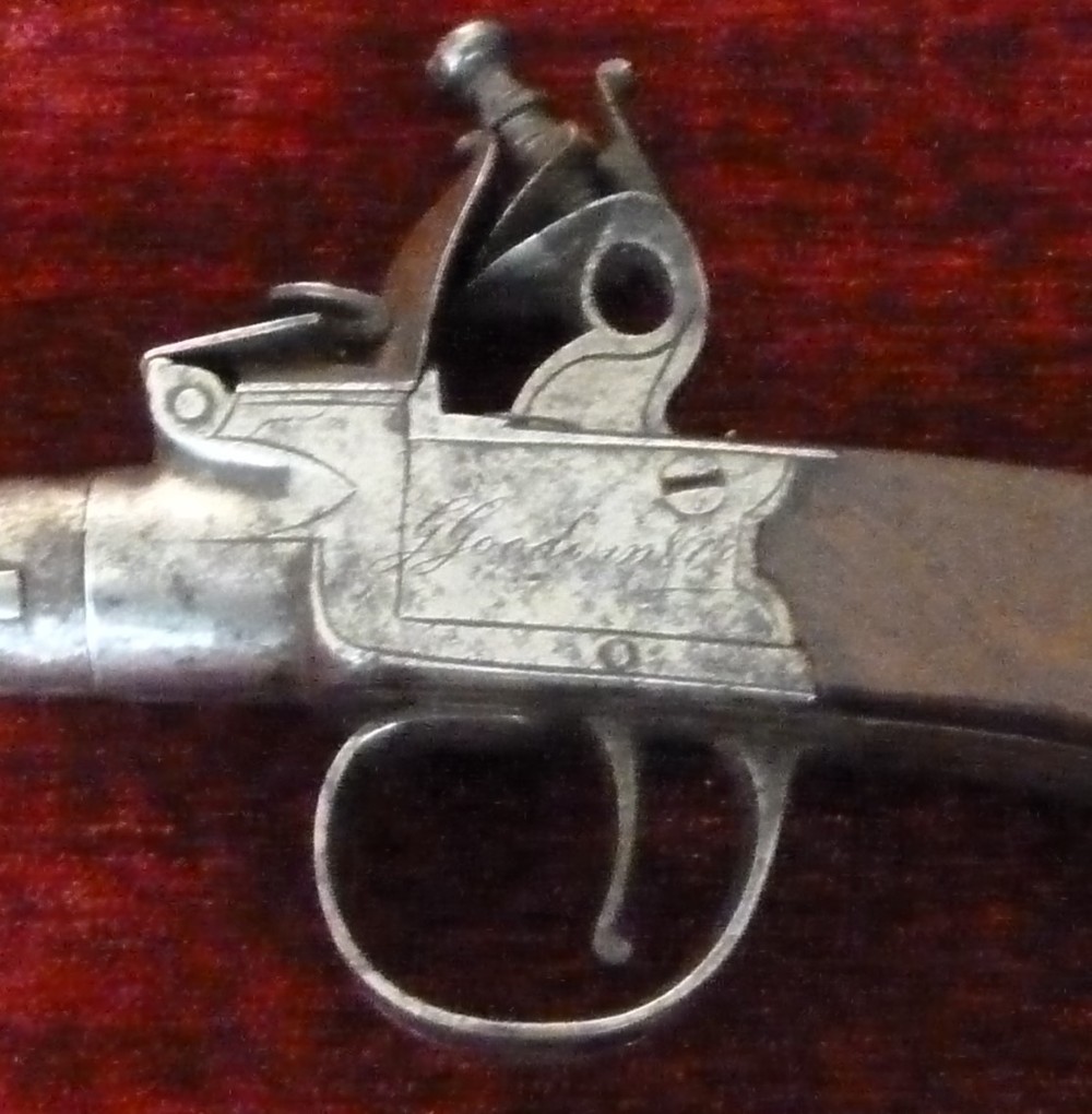 An 18th-century Georgian flintlock pocket pistol featuring an engraved steel lock mechanism, short round barrel, and smooth wooden grip. View II