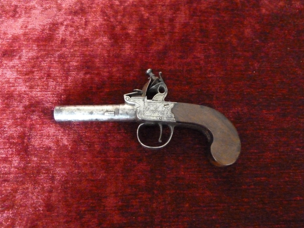 An 18th-century Georgian flintlock pocket pistol featuring an engraved steel lock mechanism, short round barrel, and smooth wooden grip. View III