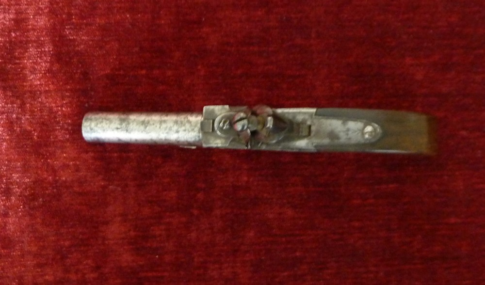 An 18th-century Georgian flintlock pocket pistol featuring an engraved steel lock mechanism, short round barrel, and smooth wooden grip. View IV