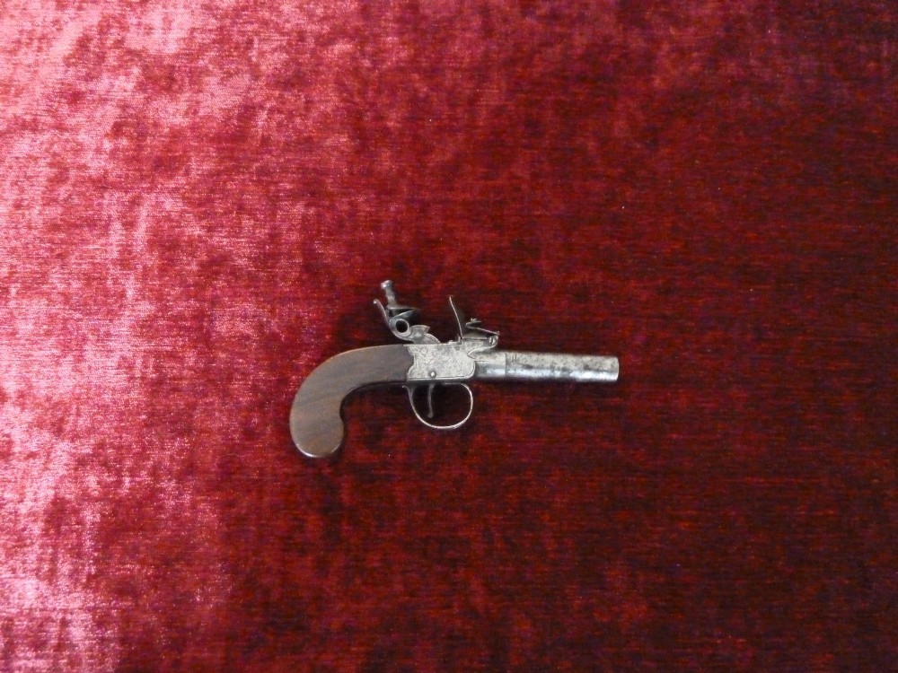 An 18th-century Georgian flintlock pocket pistol featuring an engraved steel lock mechanism, short round barrel, and smooth wooden grip. View VIII