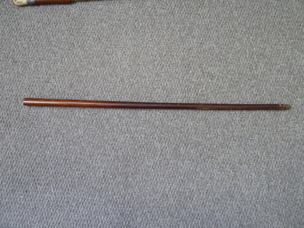 A Victorian sword stick displayed unsheathed in two parts, showcasing a stag horn handle, decorative metal ferrule, dark wooden scabbard, and a narrow steel blade. View V