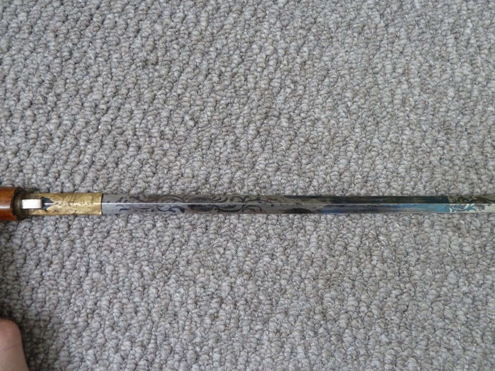 A Victorian sword stick displayed unsheathed in two parts, showcasing a stag horn handle, decorative metal ferrule, dark wooden scabbard, and a narrow steel blade. View IX