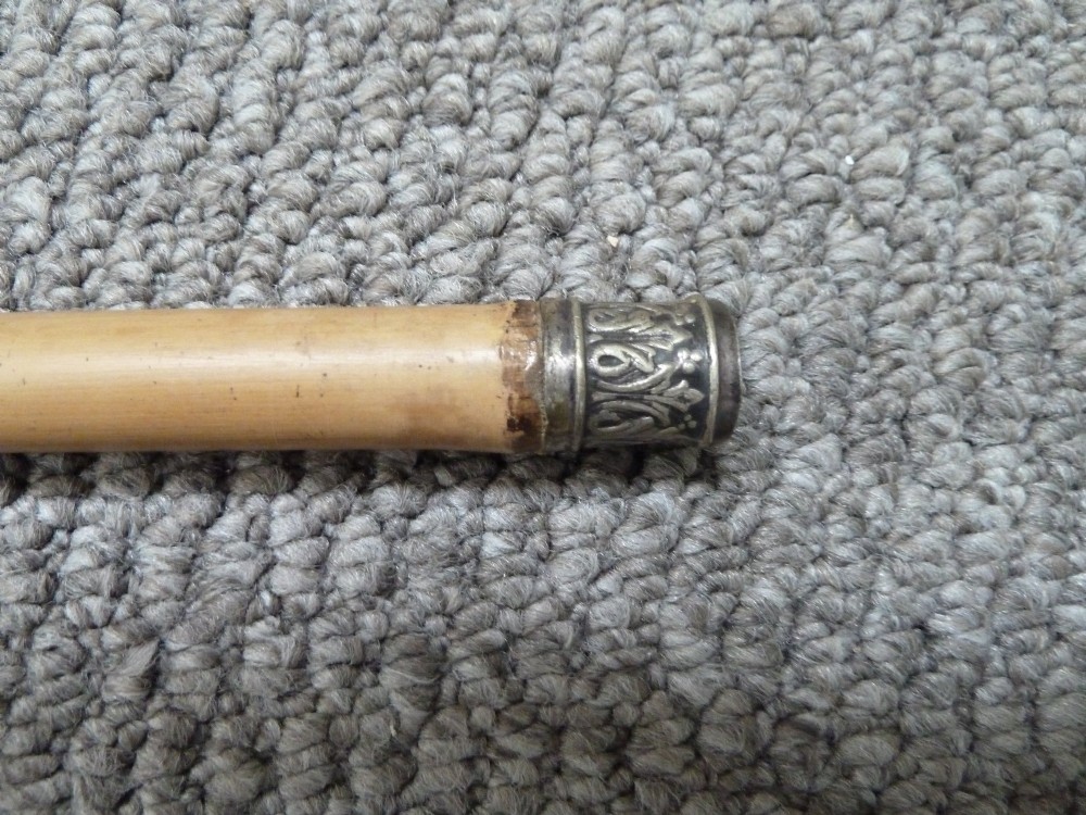 A Victorian bamboo walking stick displayed unsheathed alongside its concealed long steel blade attached to a curved bamboo crook handle. View III