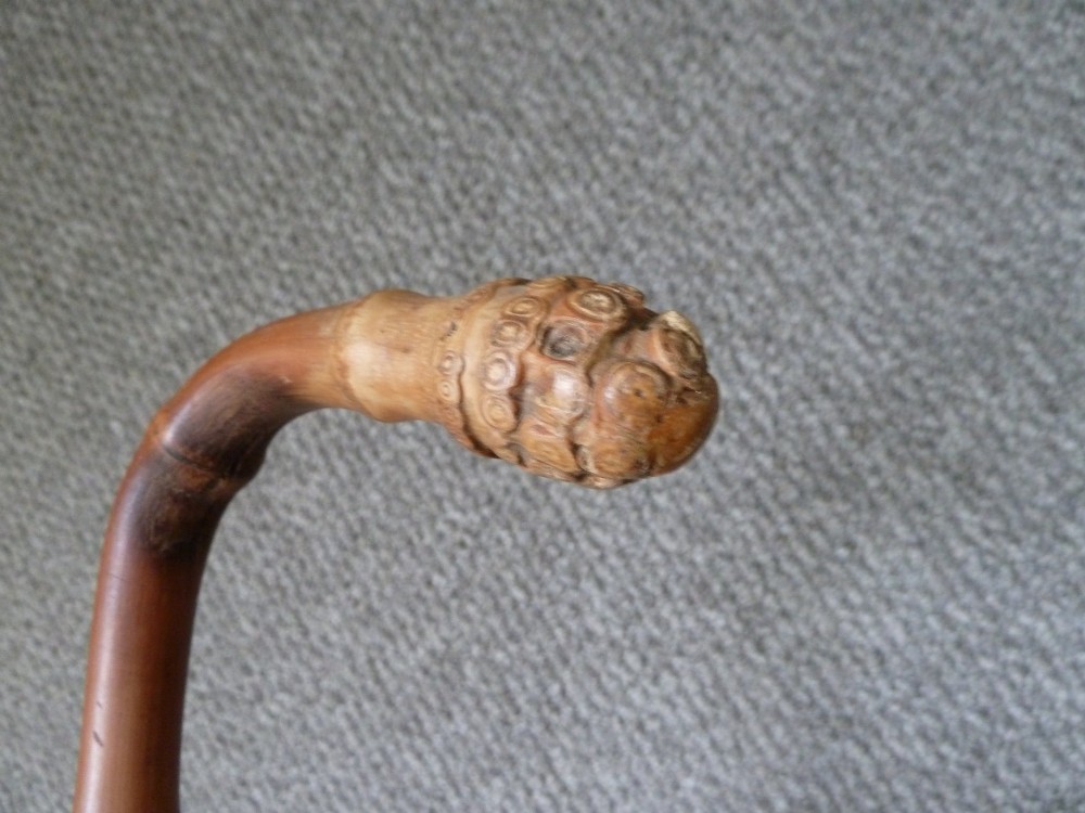 A Victorian bamboo walking stick displayed unsheathed alongside its concealed long steel blade attached to a curved bamboo crook handle. View VI