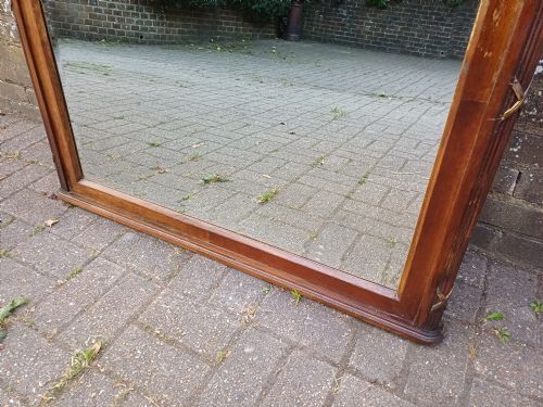 fig 5. A large Edwardian wooden overmantel mirror featuring marquetry inlay, a reeded frame with gilded cross-ribbon details, and an arched upper glass line.