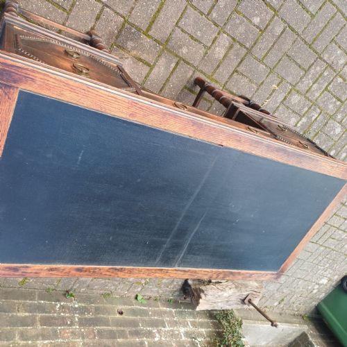 fig 2. A vintage dark oak writing desk with five drawers, geometric bead moulding, turned legs, brass handles, and a black leather inset top.