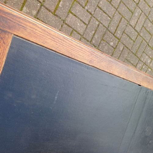 fig 3. A vintage dark oak writing desk with five drawers, geometric bead moulding, turned legs, brass handles, and a black leather inset top.