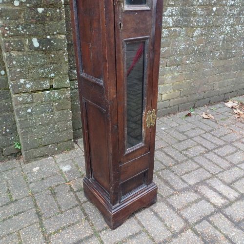 fig 3. A tall, narrow Victorian dark oak gun cupboard featuring two glass panels set into a single front door with decorative brass hinges.